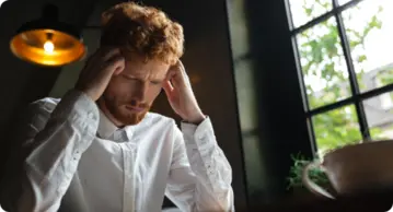 close-up-portrait-young-redhead-bearded-overworked-man-white-shirt-touching-his-head-while-sitting-office-ezgif.com-png-to-webp-converter